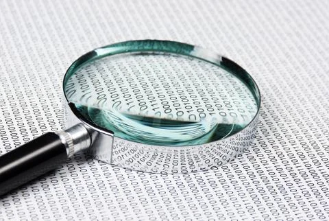 Magnifying glass on a binary code Stock Photos