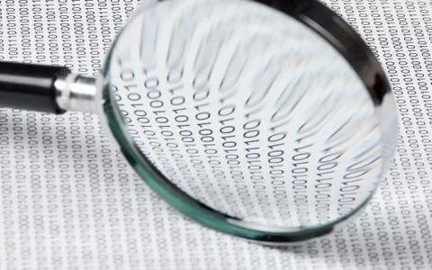 Magnifying glass on a binary code Stock Photos