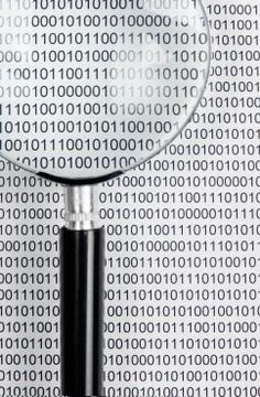 Magnifying glass on a binary code Stock Photos