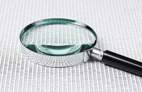 Magnifying glass on a binary code 库存照片