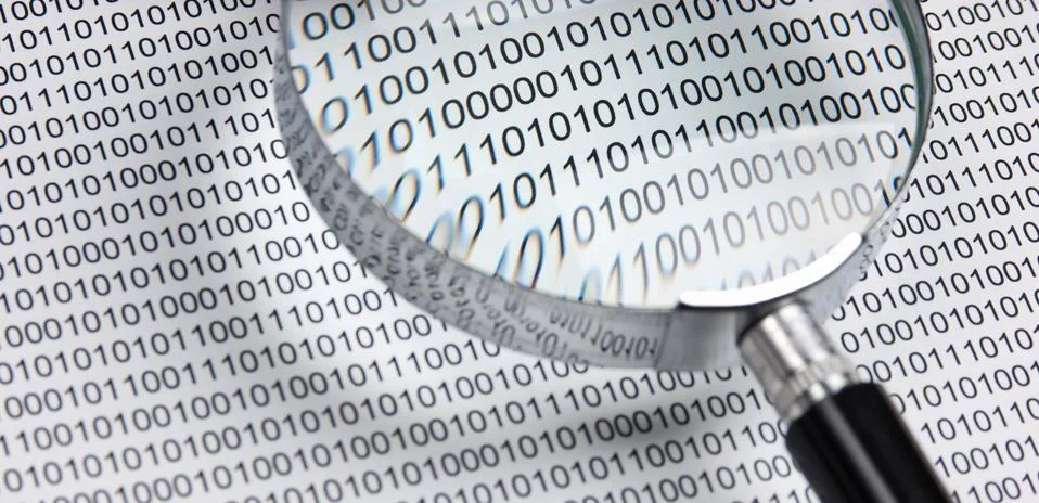 Magnifying glass on a binary code 写真素材