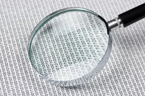Magnifying glass on a binary code 스톡 사진