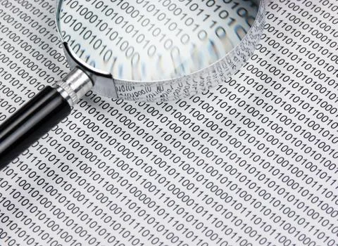 Magnifying glass on a binary code 写真素材