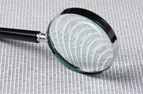 Magnifying glass on a binary code 스톡 사진