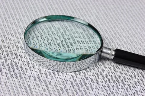 Magnifying glass on a binary code Stock Photos