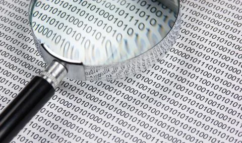 Magnifying glass on a binary code 库存照片