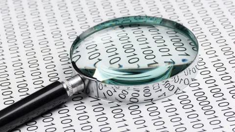 Magnifying glass on a binary code Stock Photos