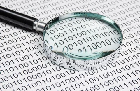 Magnifying glass on a binary code 写真素材