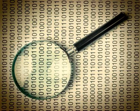 Magnifying glass on a binary code Stock Photos