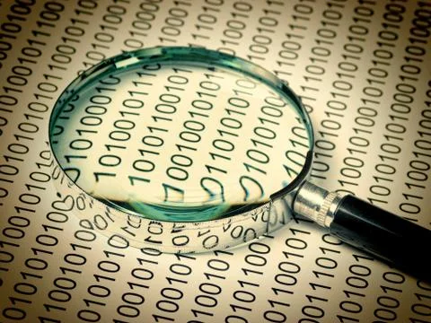Magnifying glass on a binary code Stock Photos