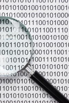 Magnifying glass on a binary code 스톡 사진