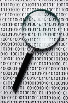 Magnifying glass on a binary code 库存照片