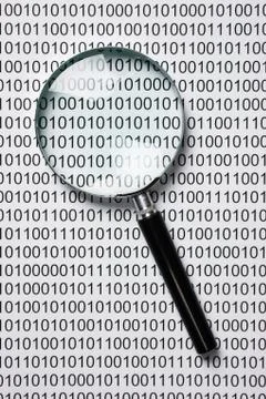 Magnifying glass on a binary code Stock Photos