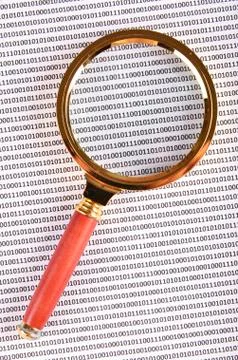 Magnifying glass on the digital code Stock Photos