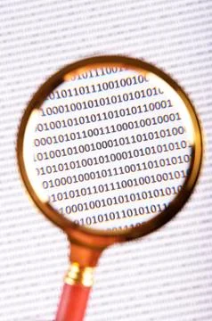 Magnifying glass on the digital code Stock Photos