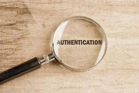 A magnifying glass emphasizes the word authentication, symbolizing verifica.. 写真素材