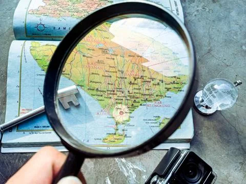 Magnifying glass exploring Bali map for travel planning 写真素材