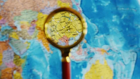 Magnifying glass exploring countries on world map Stock Footage 339806247