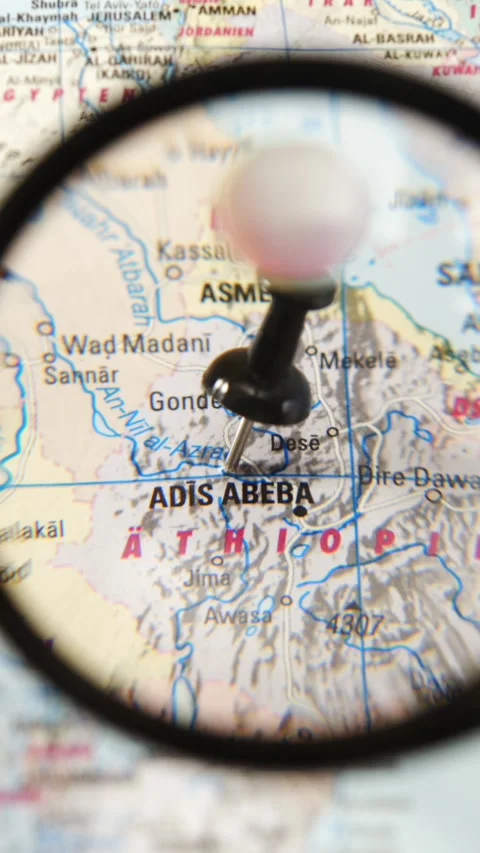Magnifying glass finding Addis Ababa on a paper map Stock Footage 341904274