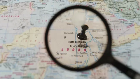 Magnifying glass finding Khartoum on a printed paper map Stock Footage 341904268