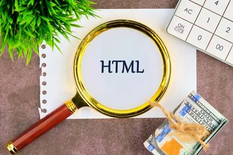 A magnifying glass focused on the word HTML placed on a sheet of paper alongs Stock Photos