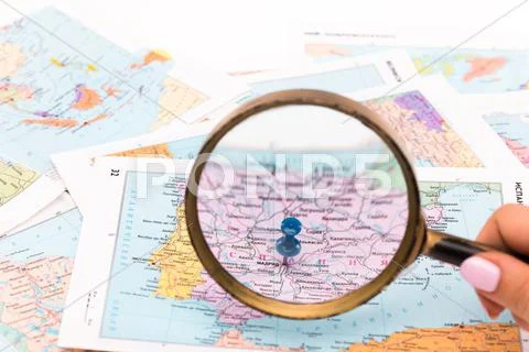 Magnifying glass on a map - close-up Stock Photos