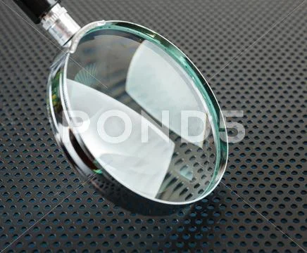 Magnifying glass on a metallic background Stock Photos