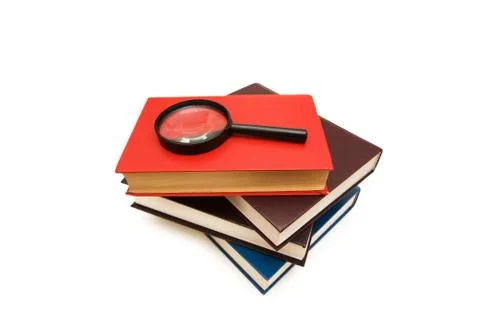Magnifying glass over the stack of books Stock Photos