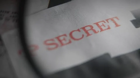 Magnifying glass pointing on red stamp of Top Secret security clearance on Stock Footage 335475158