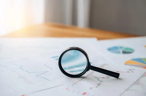 Magnifying glass on table for financial analytics research Stock Photos