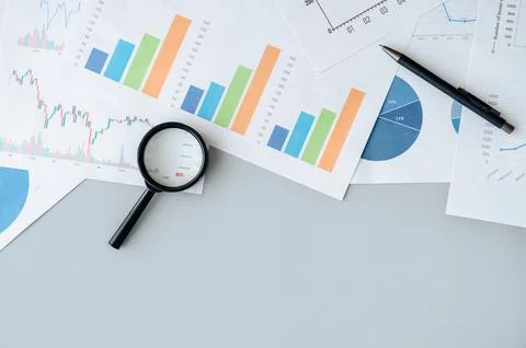 Magnifying glass on table for financial analytics research Stock Photos