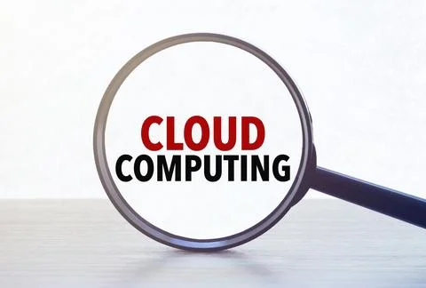 Magnifying glass with text cloud computing on wooden table. Stock Photos