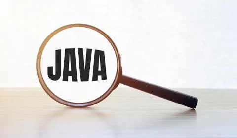 Magnifying glass with text JAVA on wooden table. 库存照片