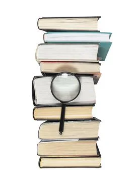Magnifying lens over books stack isolated on white background. Concept of Stock Photos