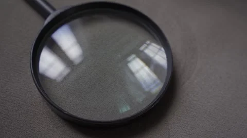Magnifying lens on sofa reflecting window as camera moves closer Stock Footage 257776371
