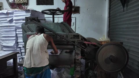 Maharashtra, India - Aug 2026: Workers in printing press cutting paper Video stock 343882148