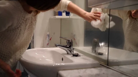 Maid cleaning mirror in the bathroom using white soft rag. Domestic service Stock Footage 123085557