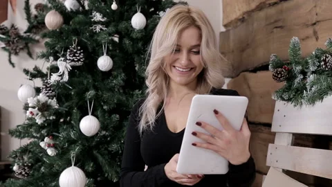 A maid communicates on the internet on her tablet in a Christmas atmosphere 스톡 동영상 99210863