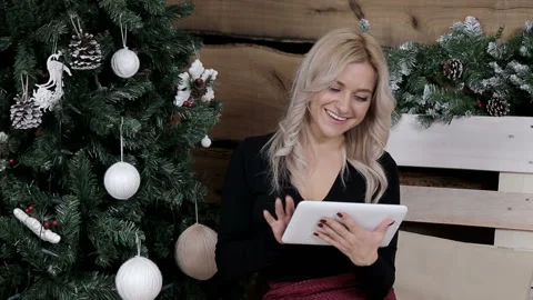 A maid communicates on the internet on her tablet in a Christmas atmosphere 스톡 동영상 99601128