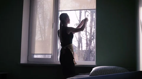 The maid raises the curtains on the window Stock Footage 88438628