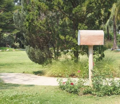 Mail box or post box in the flower garden or front of house. Stock Photos