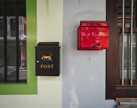 Mail boxes on a wall between adjacent houses. Stock Photos