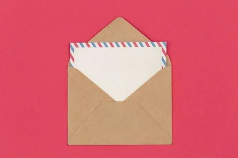 Mail envelope and blank postcard on pink background, flat lay. Stock Photos
