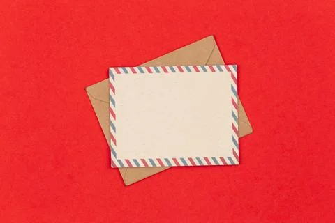 Mail envelope and blank postcard on red background, flat lay. Stock Photos