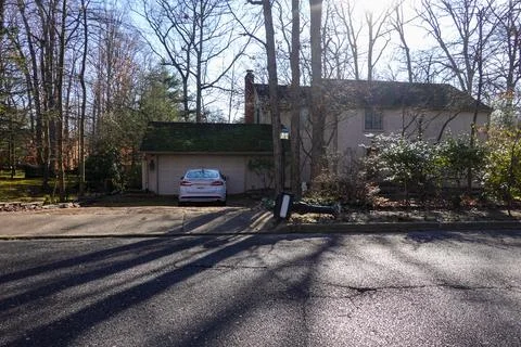 A mailbox on a post is seen on the ground in front of a house Stock Photos