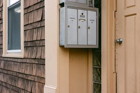 Mailboxes mounted on a wall near an entry door of a residential building with Foto stock