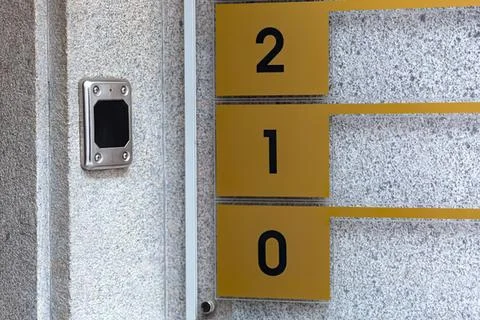 Mailboxes with yellow and black numbers on gray wall Stock Photos