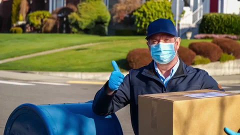 Mailman in facemask gives a thumbs up Stock Footage 147163094