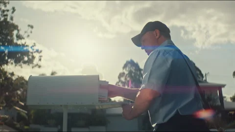 Mailman putting letters inside a mailbox in the afternoon Stock-Footage 263977178
