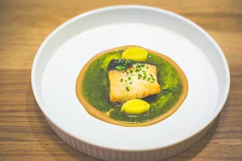 Main course of Roasted Black Cod With Green Mojo And Leek Stock Photos